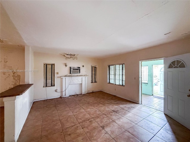 unfurnished living room with tile patterned floors and a wall mounted air conditioner