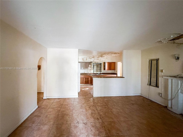 unfurnished living room featuring light tile patterned floors