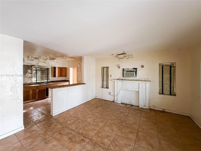 unfurnished living room with light tile patterned floors and an AC wall unit