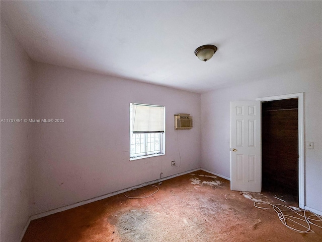 unfurnished bedroom with a closet and an AC wall unit