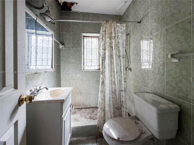 bathroom with toilet, tile walls, a shower with curtain, and vanity