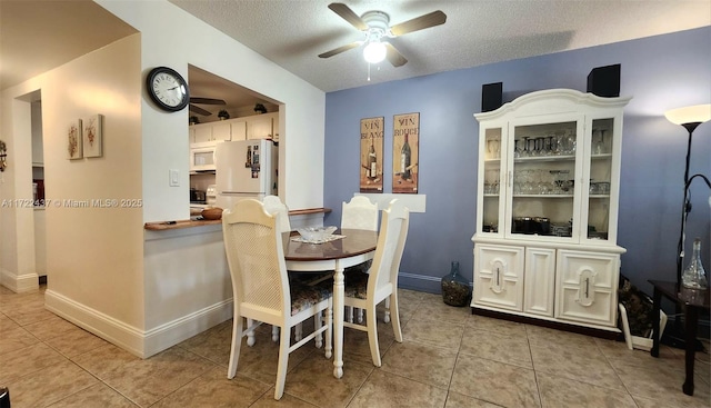 dining space with a textured ceiling, ceiling fan, and light tile patterned floors