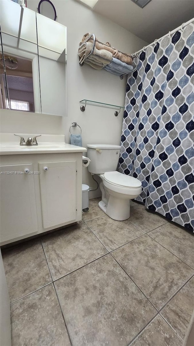 bathroom featuring toilet, tile patterned floors, and vanity