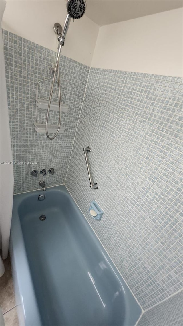 bathroom featuring tile patterned flooring and tiled shower / bath