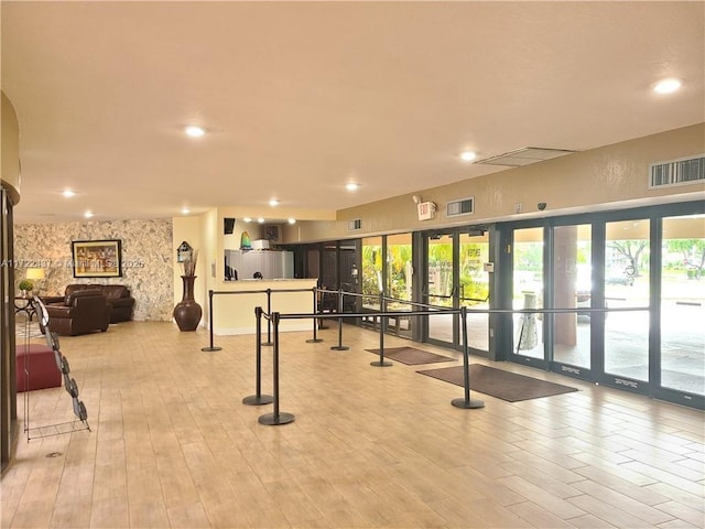 exercise room featuring french doors and light hardwood / wood-style flooring