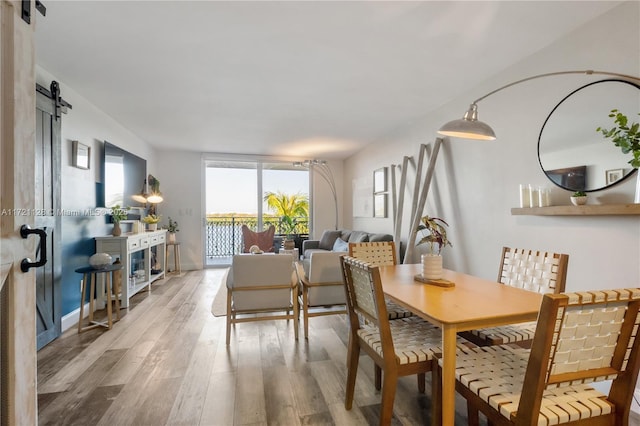 dining room featuring a barn door and hardwood / wood-style flooring