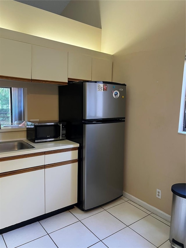 10 Via De Casas Sur Unit 205, Boynton Beach, FL 33426 - kitchen with light tile patterned floors, a sink, light countertops, white cabinetry, and stainless steel appliances