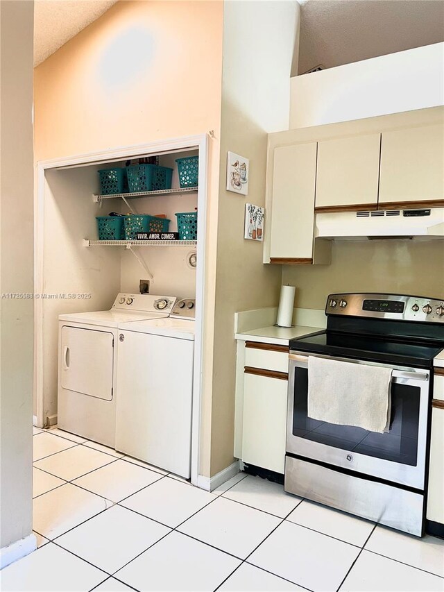 10 Via De Casas Sur Unit 205, Boynton Beach, FL 33426 - kitchen with light countertops, light tile patterned flooring, under cabinet range hood, washer and clothes dryer, and electric stove