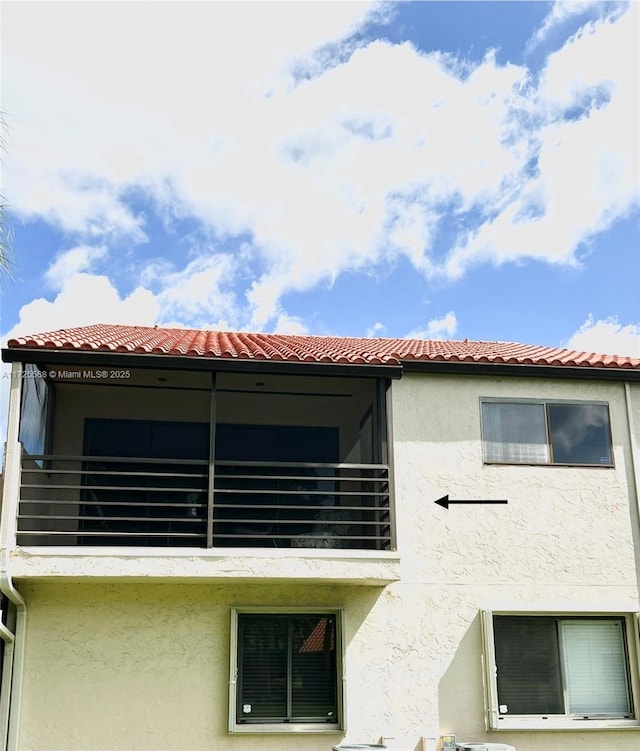 10 Via De Casas Sur Unit 205, Boynton Beach, FL 33426 - view of side of home with a tile roof, a balcony, and stucco siding