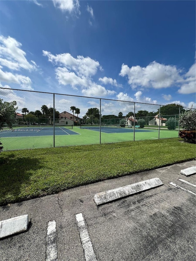 10 Via De Casas Sur Unit 205, Boynton Beach, FL 33426 - surrounding community with uncovered parking, a tennis court, fence, and a lawn