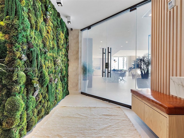 hallway featuring a wall of windows and light tile patterned floors