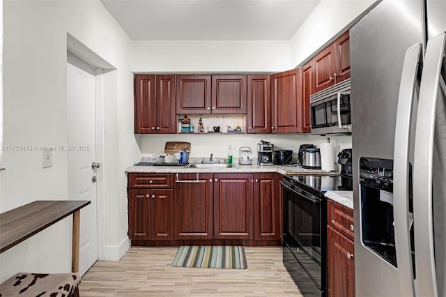 kitchen with sink, light hardwood / wood-style floors, and appliances with stainless steel finishes