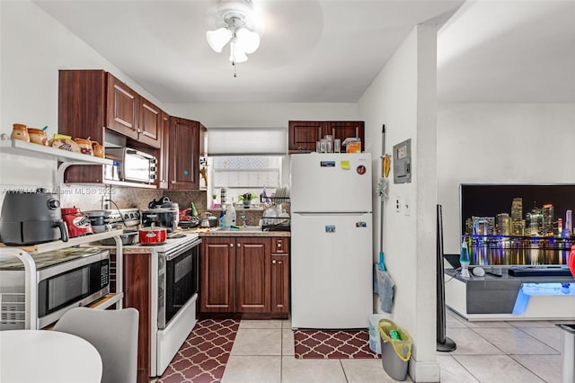 kitchen featuring electric range, light tile patterned floors, ceiling fan, white refrigerator, and tasteful backsplash