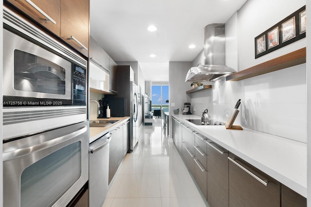 kitchen with sink, stainless steel appliances, light tile patterned floors, and island exhaust hood