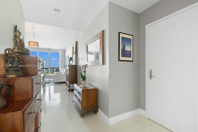 hall featuring light tile patterned floors and floor to ceiling windows