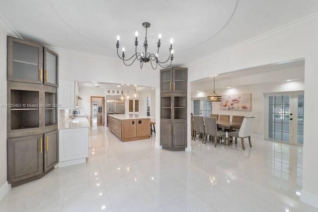 dining area featuring french doors, crown molding, and a notable chandelier