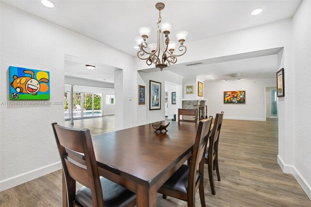 dining room with dark hardwood / wood-style floors and an inviting chandelier