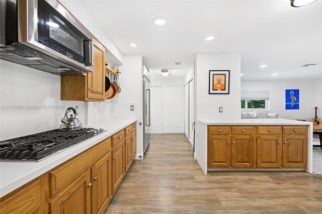 kitchen with appliances with stainless steel finishes and light hardwood / wood-style flooring