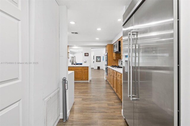 kitchen with dark hardwood / wood-style flooring, sink, and stainless steel appliances