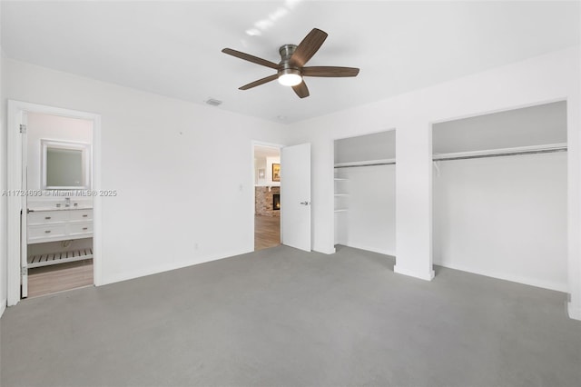 unfurnished bedroom with multiple closets and ceiling fan