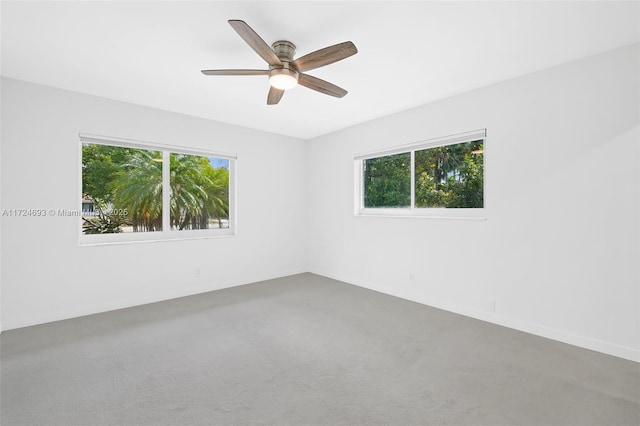 spare room with ceiling fan and plenty of natural light