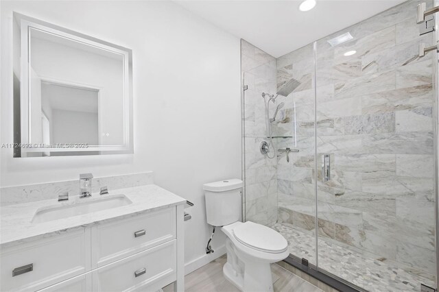 bathroom with vanity, hardwood / wood-style flooring, toilet, and walk in shower