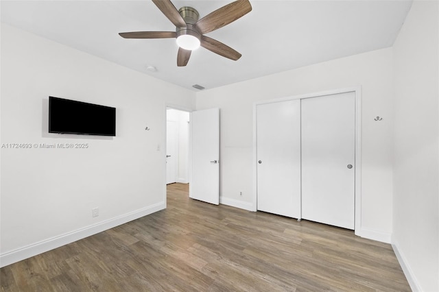 unfurnished bedroom featuring wood-type flooring, ceiling fan, and a closet