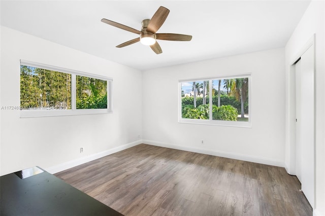 unfurnished bedroom with dark hardwood / wood-style flooring, ceiling fan, and a closet