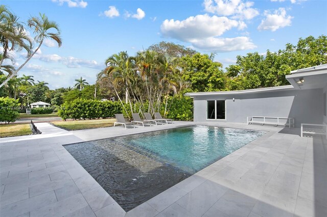 pool at dusk featuring a patio area