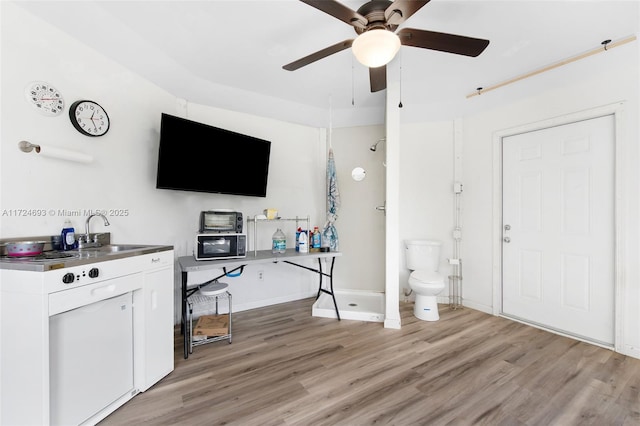 interior space with sink, ceiling fan, and light wood-type flooring