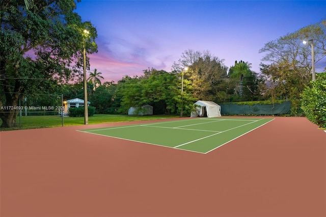 view of sport court with a lawn, basketball court, and a shed