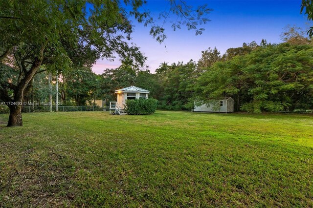 yard at dusk featuring a gazebo and a shed