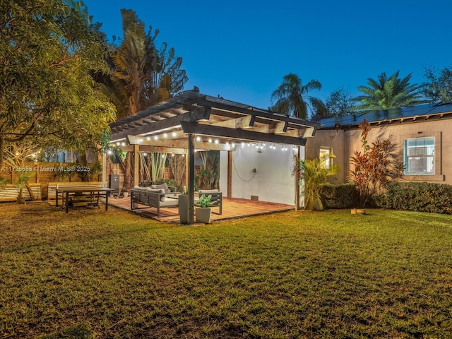 back of house with outdoor lounge area, a yard, and a pergola