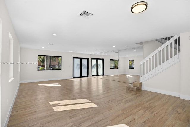 unfurnished living room featuring light hardwood / wood-style flooring and french doors