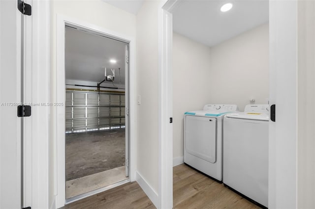 laundry room featuring washing machine and clothes dryer and light hardwood / wood-style floors