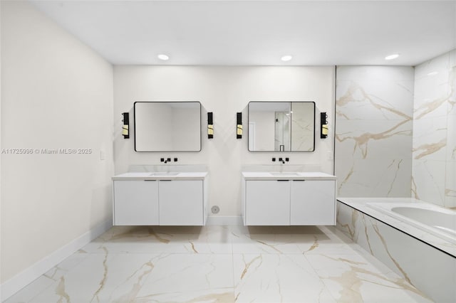 bathroom featuring vanity and a relaxing tiled tub