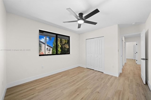 unfurnished bedroom featuring ceiling fan, a closet, and light wood-type flooring