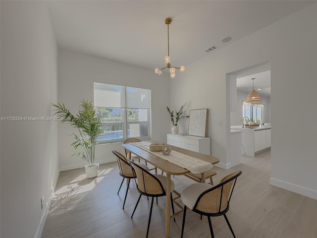 dining space featuring baseboards, visible vents, and light wood-style floors