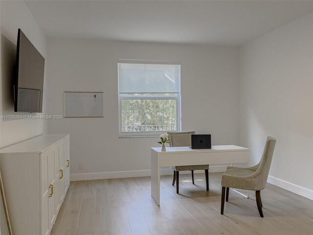 home office with light hardwood / wood-style floors