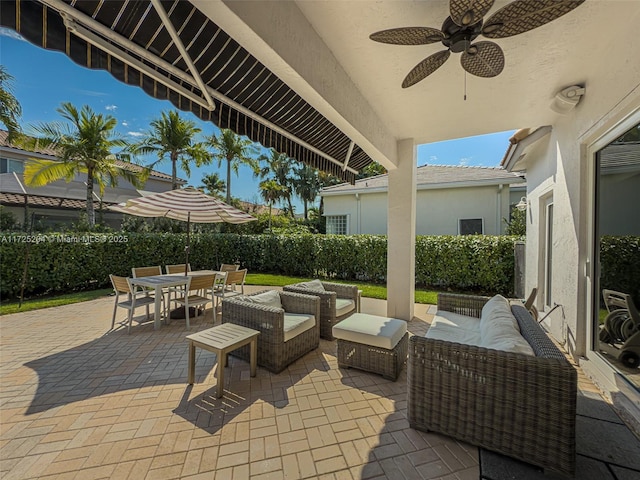 view of patio with ceiling fan, an outdoor living space, and outdoor dining space