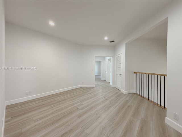 unfurnished room with light wood-type flooring, baseboards, visible vents, and recessed lighting