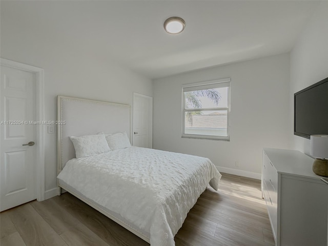 bedroom featuring light wood-style flooring and baseboards