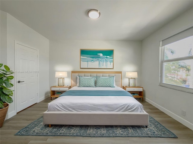 bedroom with wood finished floors and baseboards