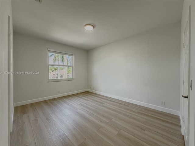 empty room featuring light wood-style flooring and baseboards