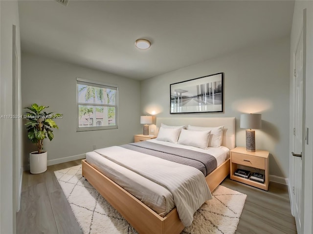 bedroom featuring baseboards and wood finished floors