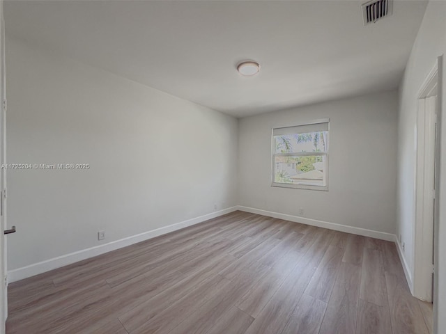 unfurnished room with baseboards, visible vents, and light wood finished floors