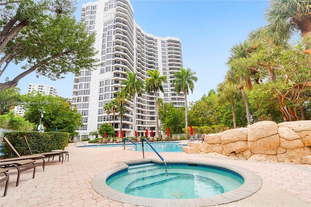 view of pool with a patio area and a hot tub