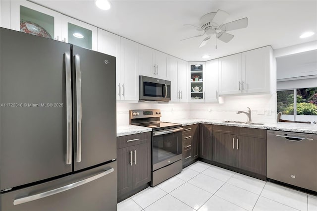 kitchen with sink, stainless steel appliances, dark brown cabinets, and white cabinetry