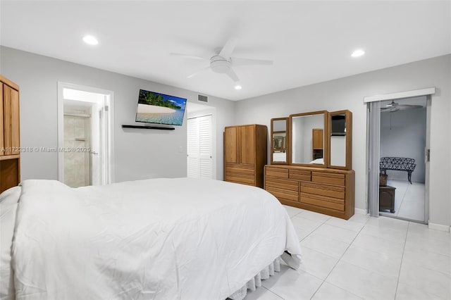 bedroom featuring ensuite bath, light tile patterned flooring, and ceiling fan