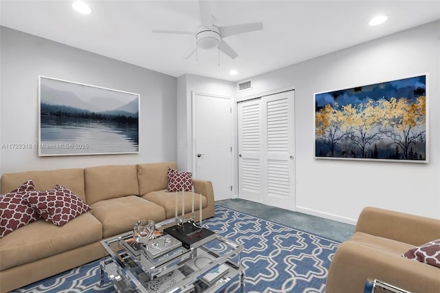 living room featuring ceiling fan and dark colored carpet